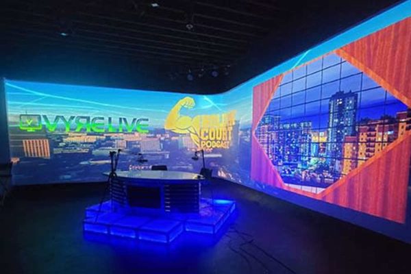 Podcast set with microphones and wraparound projected backgrounds at VYRE Live Studios