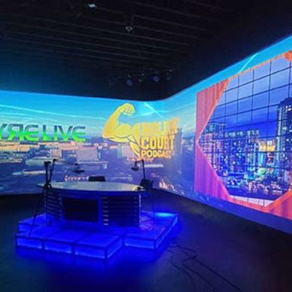Podcast set with microphones and wraparound projected backgrounds at VYRE Live Studios
